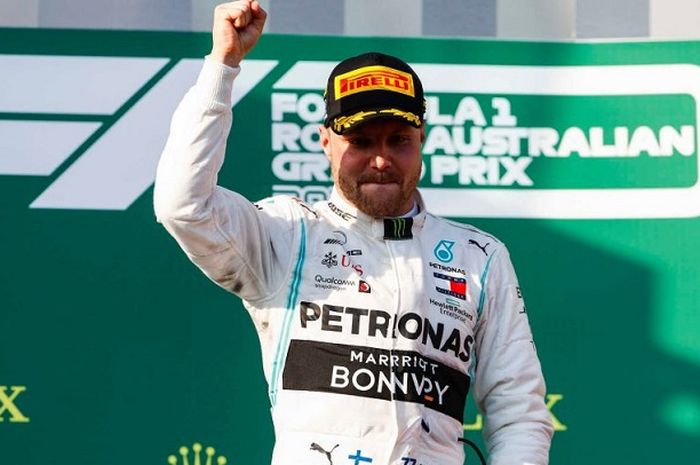 Pembalap Mercedes, Valtteri Bottas, berpose di podium setelah keluar sebagai juara GP Australia di Sirkuit Melbourne Grand Prix, Minggu (17/3/2019).