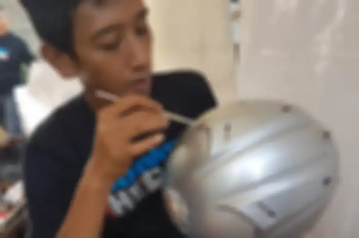 Ilustrasi. Anggota komunitas Belajar Helm sedang cuci helm waterless