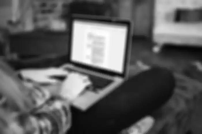 Ilustrasi mahasiswa sedang menggunakan Microsoft Word untuk mengerjakan skripsi