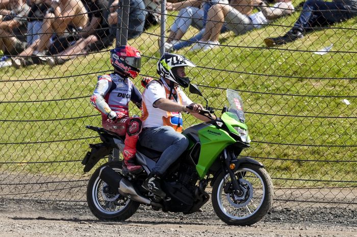 Pembalap Gresini, Marc Marquez, kembali ke garasi dibantu marshal setelah terjatuh pada sprint race MotoGP Belanda 2024 di Sirkuit Assen, Sabtu (29/6/2024).