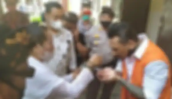 I Gede Ary Astina alias Jerinx diperciki air suci (tirta) oleh Ida Rsi Bujangga yang merupakan ibunda Jerinx jelang sidang di kasus dugaan ujaran kebencian 'IDI Kacung WHO' di Pengadilan Negeri Denpasar, Selasa (10/11/2020).