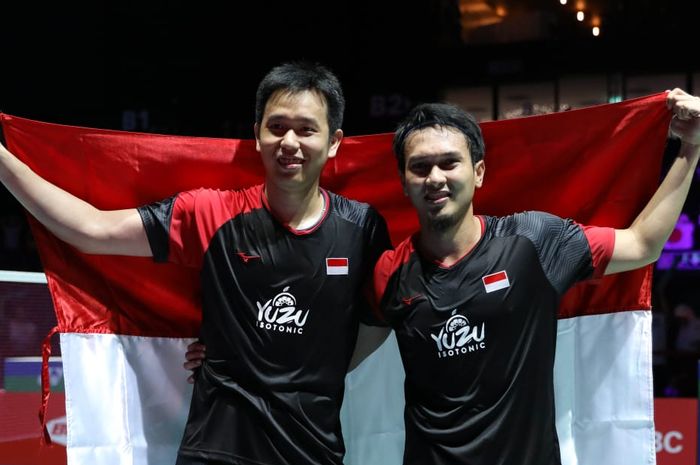 Pasangan ganda putra Indonesia, Hendra Setiawan dan Mohammad Ahsan, berpose dengan bendera Merah Putih usai memenangi medali emas Kejuaraan Dunia 2019 di Basel, Swiss, Minggu (25/8/2019).