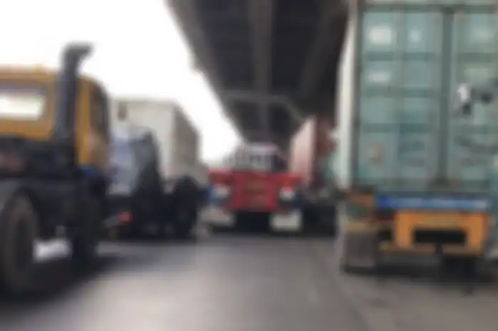 ILUSTRASI. Sopir truk kontainer kasih cara ke pengendara motor agar bisa menyalip dengan aman.