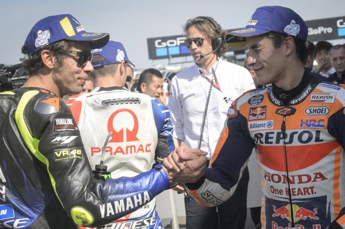 Valentino Rossi dan Marc Marquez berjabat tangan setelah kualifikasi MotoGP Inggris di Sirkuit Silverstone, Inggris, 24 Agustus 2019.