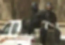 Anggota Fedayeen mengenakan helm Darth Vader yang sangat besar.