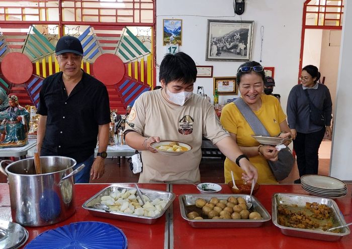 Beberapa pengunjung mengambil hidangan vegetarian yang disajikan setelah bersama-sama membersihkan patung dewa dewi di Vihara Maha Brahma atau Klenteng Pan Kho Bio. Kegiatan pembersihan ini, yang disebut Mandi Rupang, merupakan tradisi tahunan yang dilaksanakan beberapa hari sebelum Hari Raya Imlek.