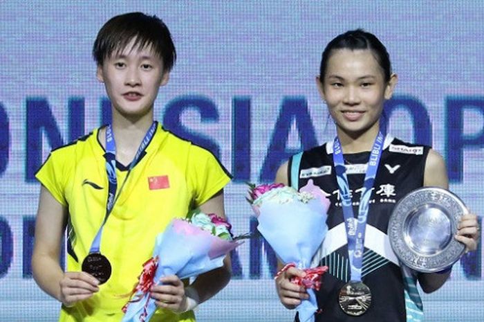 Pebulu tangkis tunggal putri China, Chen Yufei (kiri), dan Tai Tzu Ying (Taiwan) berpose di podium Indonesia Open 2018, di Istora Senayan Jakarta, Minggu (8/7/18).