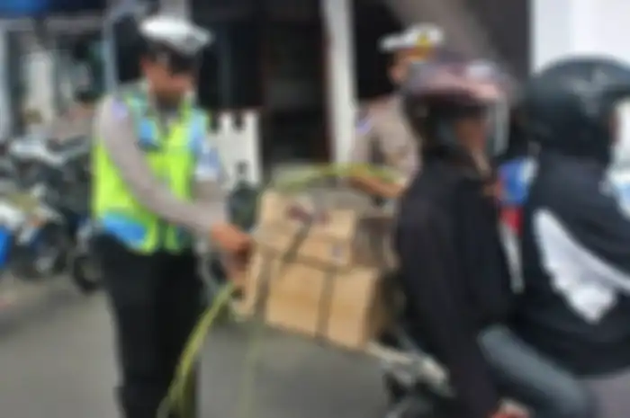 Polisi memasangkan janur ke kendaraan pemudik sebagai tanda