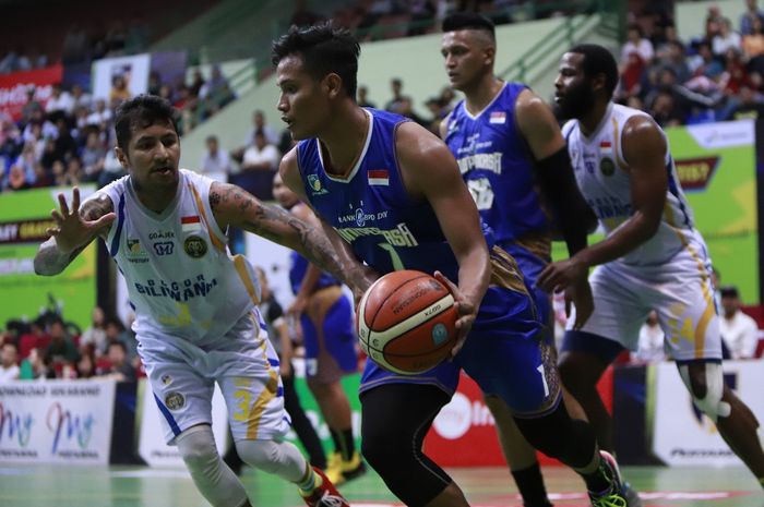 Pemain BPD DIY Bima Perkasa Jogja, M Alan As'adi (jersey biru), mendribel bola seraya dijaga pemain Bogor Siliwangi, Kelly Purwanto, pada lanjutan laga seri reguler IBL Pertamax 2018-2019 di GOR UNY, Yogyakarta, Jumat (15/2/2019).