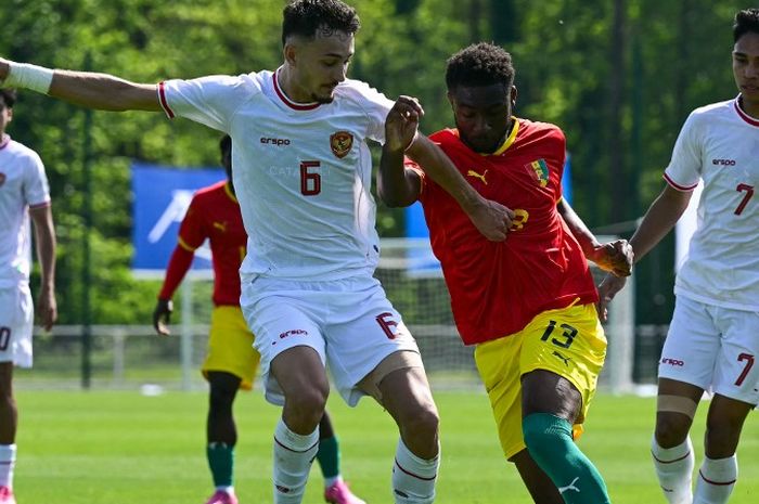 Ivar Jenner (kiri) berduel dengan Madiou Keita dalam laga play-off menuju Olimpiade 2024 antara timnas U-23 Indonesia vs Guinea di Clairefontaine, Prancis (9/5/2024).