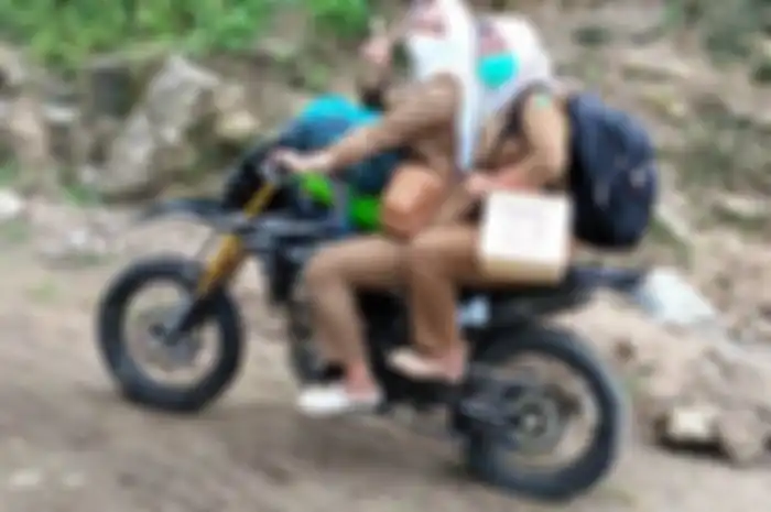 Bidan Dewi, bidan asal Cianjur yang rela naik motor trail terabas pelosok hutan demi bantu persalinan.