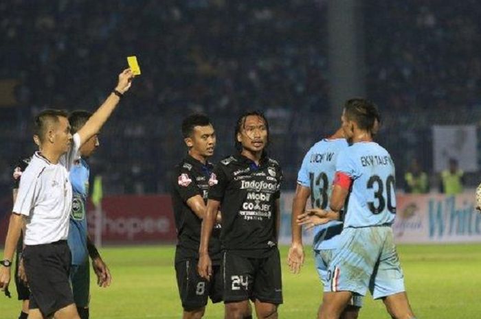 Pemain Persib Bandung Hariono (tengah) terkena kartu kuning.