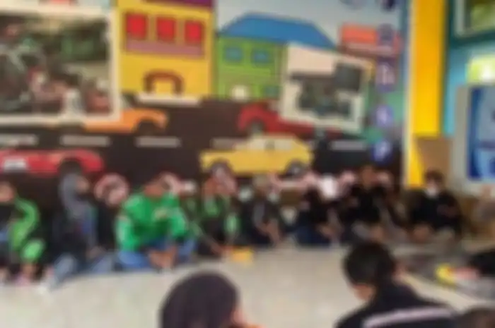 Polisi bersama kawanan driver ojol tengah berdiskusi terkait dengan penerapan sistem tilang elektronik.