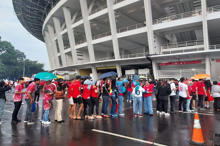 Suporter timnas Indonesia yang rela antri dibawah giyuran gerimis ke Stadion Utama Gelora Bung Karno (SUGBK), Jakarta, Selasa (11/6/2024).