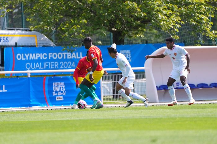 Penyerang Timnas U-23 Indonesia Witan Sulaeman yang berusaha mengambil bola dari pemain Guinea di laga playoff Olimpiade 2024 Paris di Clairefontaine-en-Yvelines, Ile-de-France, Prancis, Kamis (9/5/2024).