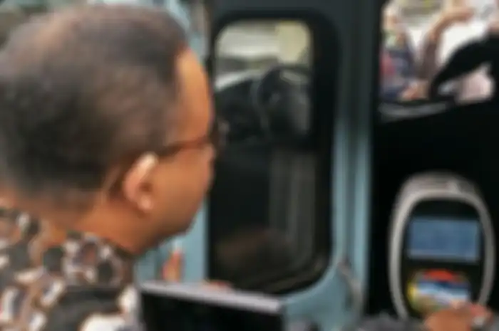 Gubernur Anies menempelkan kartu OK Otrip pada mesin tap di angkot saat simulasi