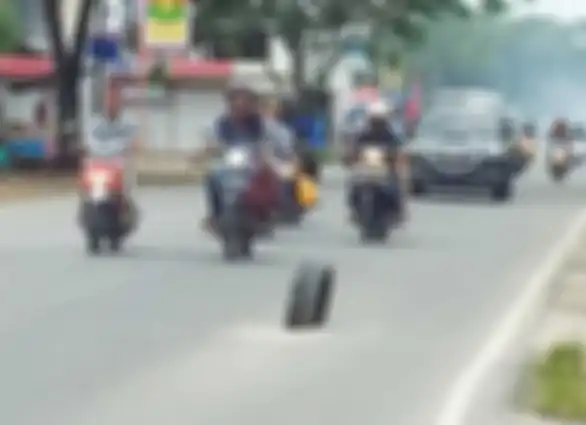Foto ilustrasi jalan berlubang yang diberikan rambu berupa ban bekas yang ditancapkan ke dalam lubang tersebut