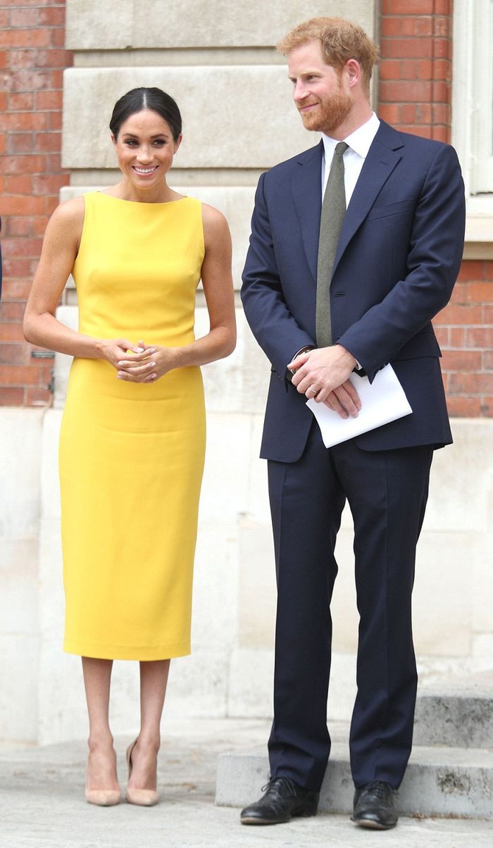 Meghan Markle terlihat anggun dengan balutan midi dress kuning cerah
