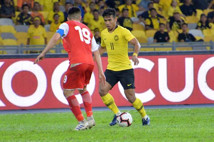 Penyerang timnas Malaysia, Safawi Rasid yang mencoba melewati bek sekaligus kapten timnas Tajikistan, Ahtam Nazarov pada laga uji coba di Stadion Nasional Bukit Jalil, Kuala Lumpur, 9 November 2019.  