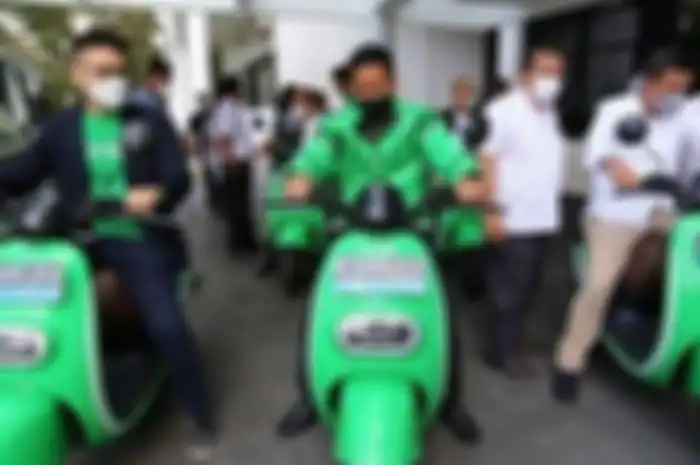 Ilustrasi foto driver ojol saat menjajal motor listrik.