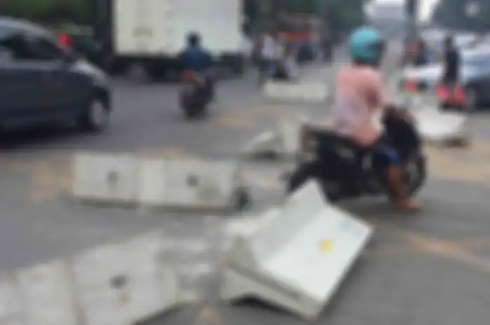 warga bongkar pembatas jalan di salah satu simpang di Mampang Prapatan