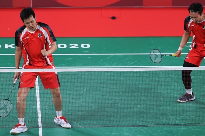 Pasangan ganda putra Indonesia, Mohammad Ahsan/Hendra Setiawan, bereaksi pada laga melawan Aaron Chia/Soh Woi Yik (Malaysia) di Musashino Forests Sport Plaza, Senin (26/7/2021).