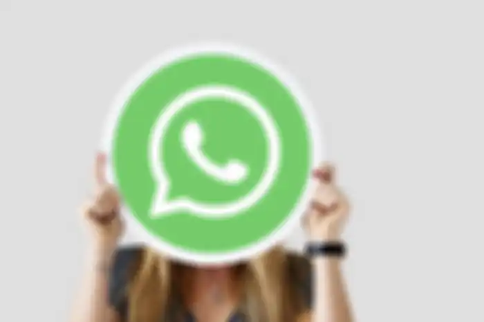 Woman showing a WhatsApp Messenger icon