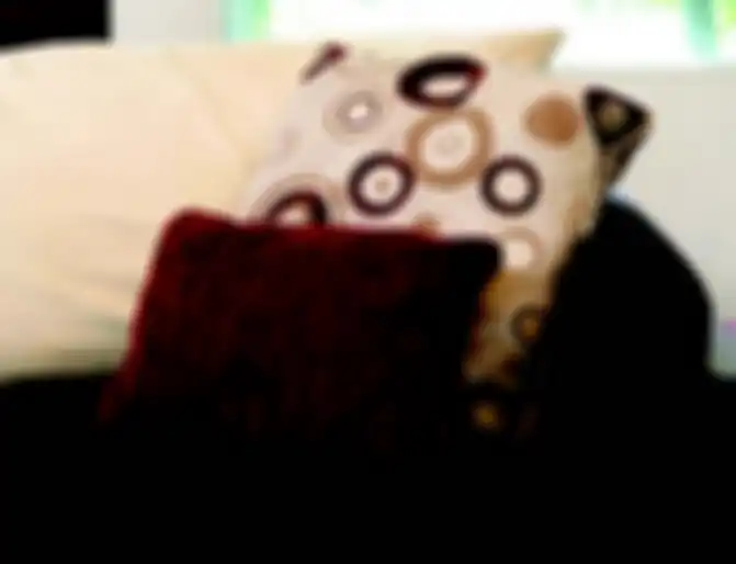 Motif bulat pada bantal sebagai sentuhan retro yang mengubah suasana ruang keluarga.