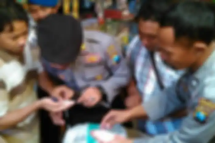 Periksa Beras- Sejumlah anggota Polres Bojonegoro memeriksa beras di pasar Bojonegoro dalam operasi pasar mengantisipasi beredarnya beras plastik, Rabu (30/5). 