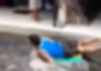 Unik! Ditarik Motor, Orang Ini Bersurfing Ria Dijalanan Saat Bajir