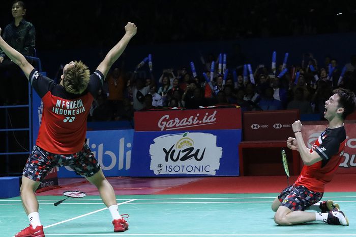 Pasangan ganda putra Indonesia, Marcus Fernaldi Gideon/Kevin Sanjaya Sukamuljo, bereaksi setelah memastikan diri menjadi juara Indonesia Open 2019 di Istora Senayan, Jakarta, Minggu (21/7/2019).