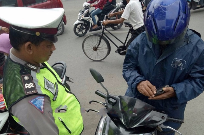 Seorang pengendara motor terjaring razia.