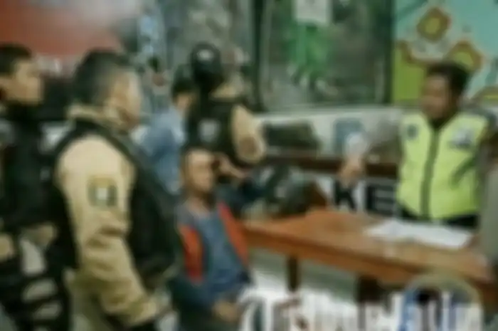 Pria yang terlibat perkelahian diamankan di kantor polisi.