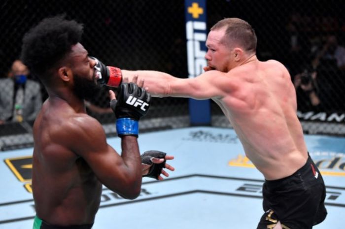 Petr Yan (kanan) saat mendaratkan pukulan tepat mengenai wajah Aljamain Sterling (kiri) saat bentrok pada ajang UFC 259, Minggu (7/3/2021).