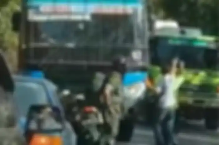Anggota TNI memalangkan motor di tengah jalan hadang bus ngeblong di Lumajang.