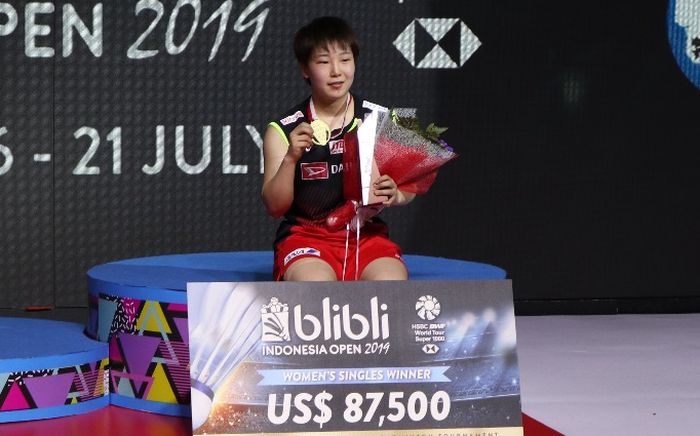 Pebulu tangkis tunggal putri Jepang, Akane Yamaguchi, berpose di podium kampiun Indonesia Open 2019 setelah memenangi laga final atas Pusarla Venkata Sindhu (India) di Istora Senayan, Jakarta, Minggu (21/7/2019).