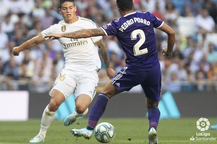 Gelandang serang Real Madrid, James Rodriguez, berusaha melewati hadangan pemain Real Valladolid, Pedro Porro, ketika kedua tim bertemu pada pekan kedua La Liga Spanyol, Ahad (25/8/2019) di Stadion Santiago Bernabeu, Madrid.