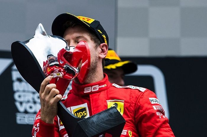 Sebastian Vettel (Ferrari) saat mencium trofi yang ia dapatkan setelah finis sebagai runner up F1 GP Jerman 2019, Minggu (28/7/2019)