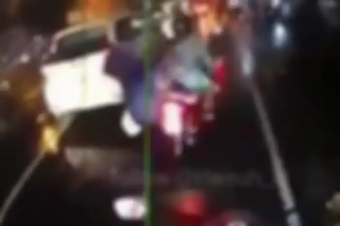 Seorang pembonceng motor terjungkal karena jas hujan masuk ke gir motor.