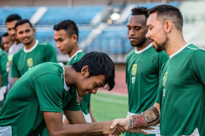 Mochamad Supriadi bersalaman dengan para pemain Persebaya di sesi latihan, Senin (20/5/2019).