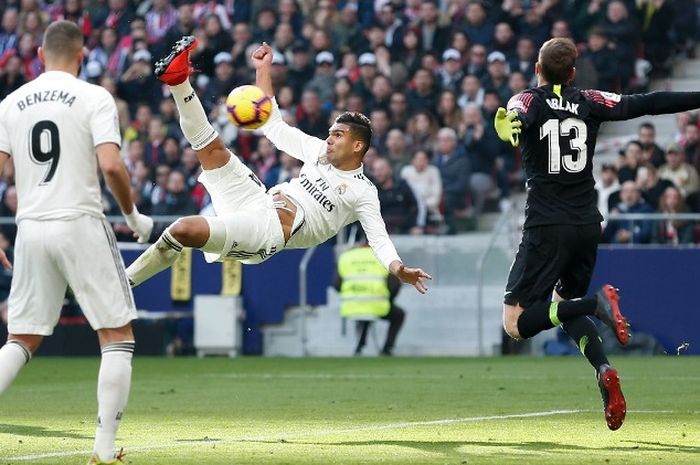 Pemain Real Madrid, Casemiro, melakukan gol salto ke gawang Atletico Madrid dalam laga di Wanda Metropolitano, Sabtu (9/2/2019)