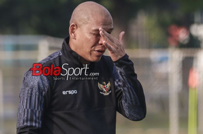 Pelatih timnas U-17 Indonesia, Nova Arianto, sempat memegangi wajah saat memantau para pemainnya berlatih di Lapangan B, Senayan, Jakarta, Kamis (8/8/2024).