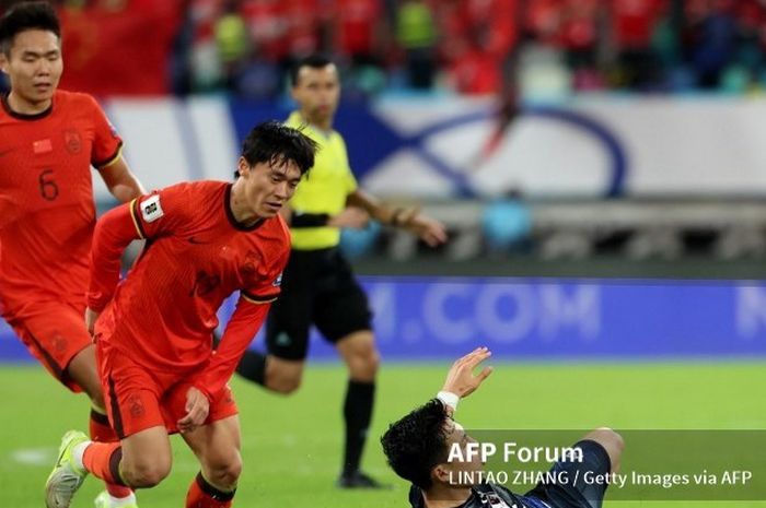 Pemain Timnas China, Hu Hetao (tengah), berduel dengan gelandang Timnas Jepang Wataru Endo.
